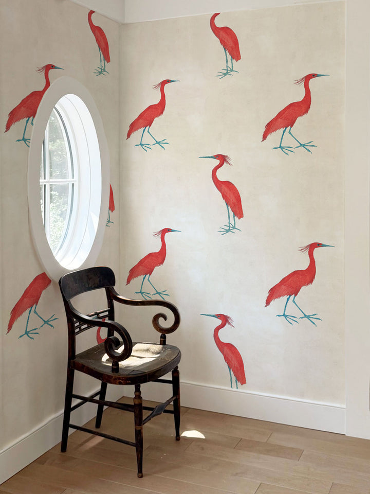 Ivory wallpaper with repeating red egret bird pattern on a wall, room view