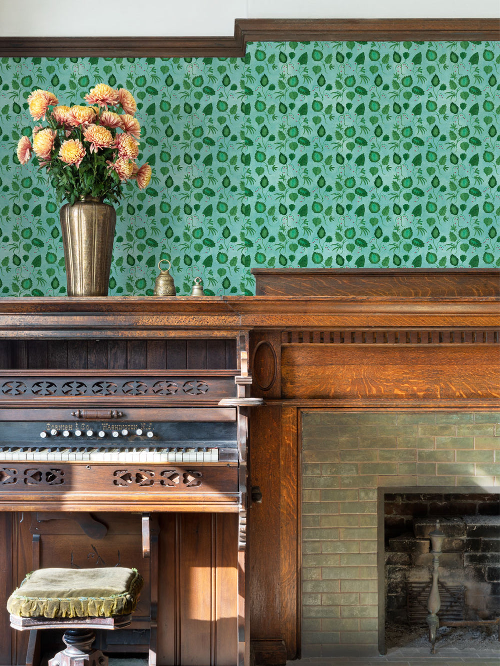 All-over green leaf wallpaper covering the wall above a fireplace