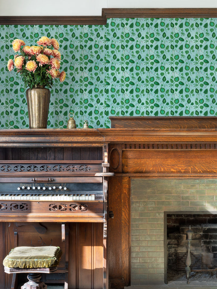 Green botanical all-over wallpaper pattern on wall above a mantel and fireplace