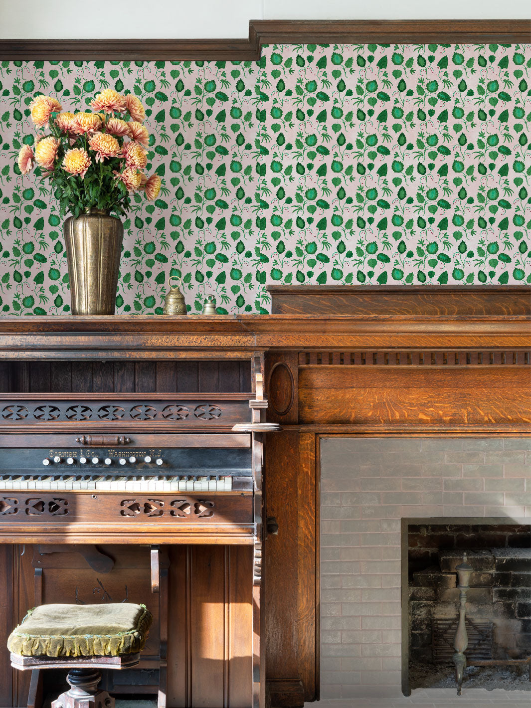 Green leaf patterned wallpaper installed on a wall with blush pink ground.