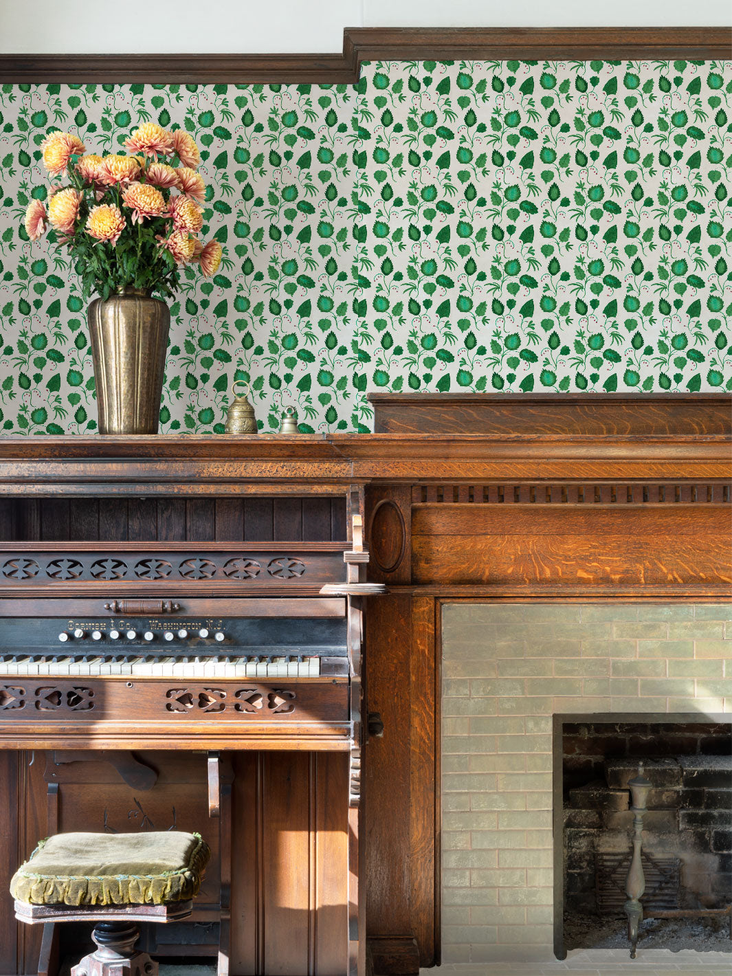 Green leaf wallpaper with repeating motif across a wide wall panel