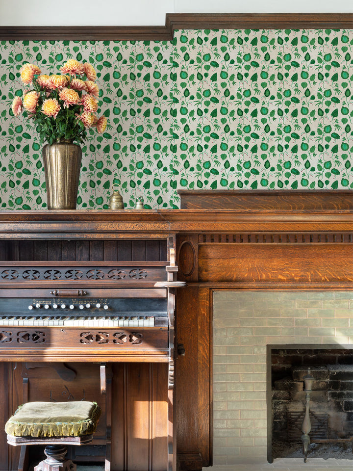 Wall wallpaper with repeating green foliage and red dotted blooms on a light background