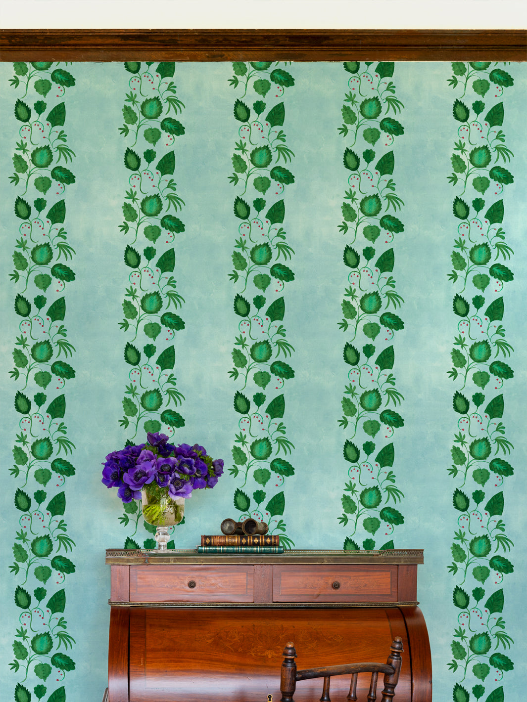 Wallpaper with repeating green vine and white berry flowers on blue vertical stripes