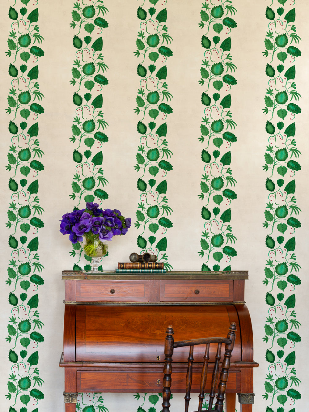 Ivory wallpaper with repeating vertical green vine and leaf stripes with red berries.
