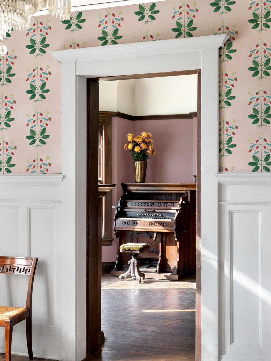 Blush strawberry wallpaper covering room walls with framed doorway opening