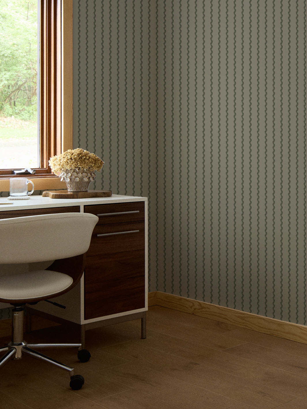 Grey-green fern stripe wallpaper in a home office with walnut desk and dried hydrangeas