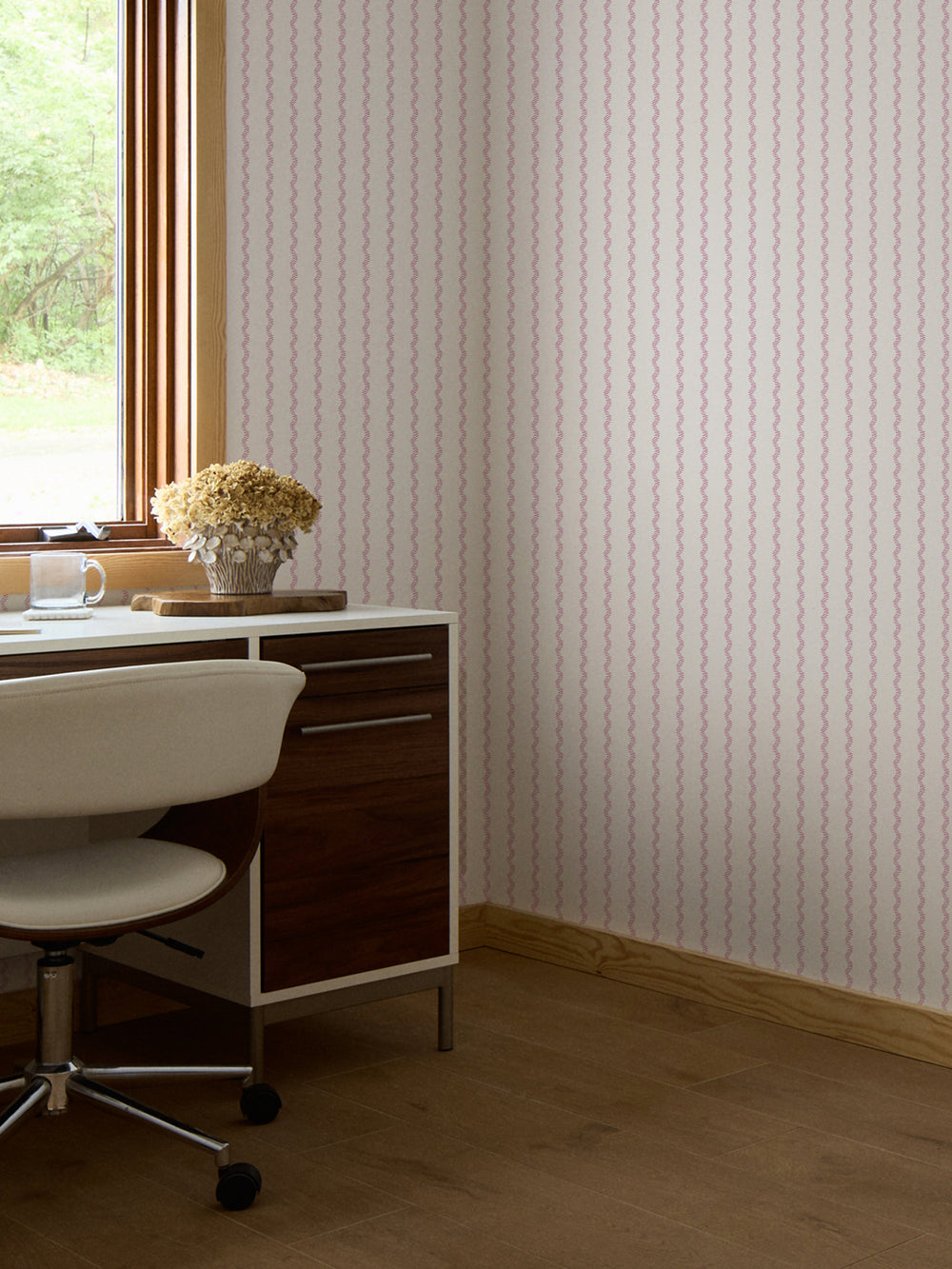 Pink and cream fern stripe wallpaper in an office with walnut desk and dried hydrangeas