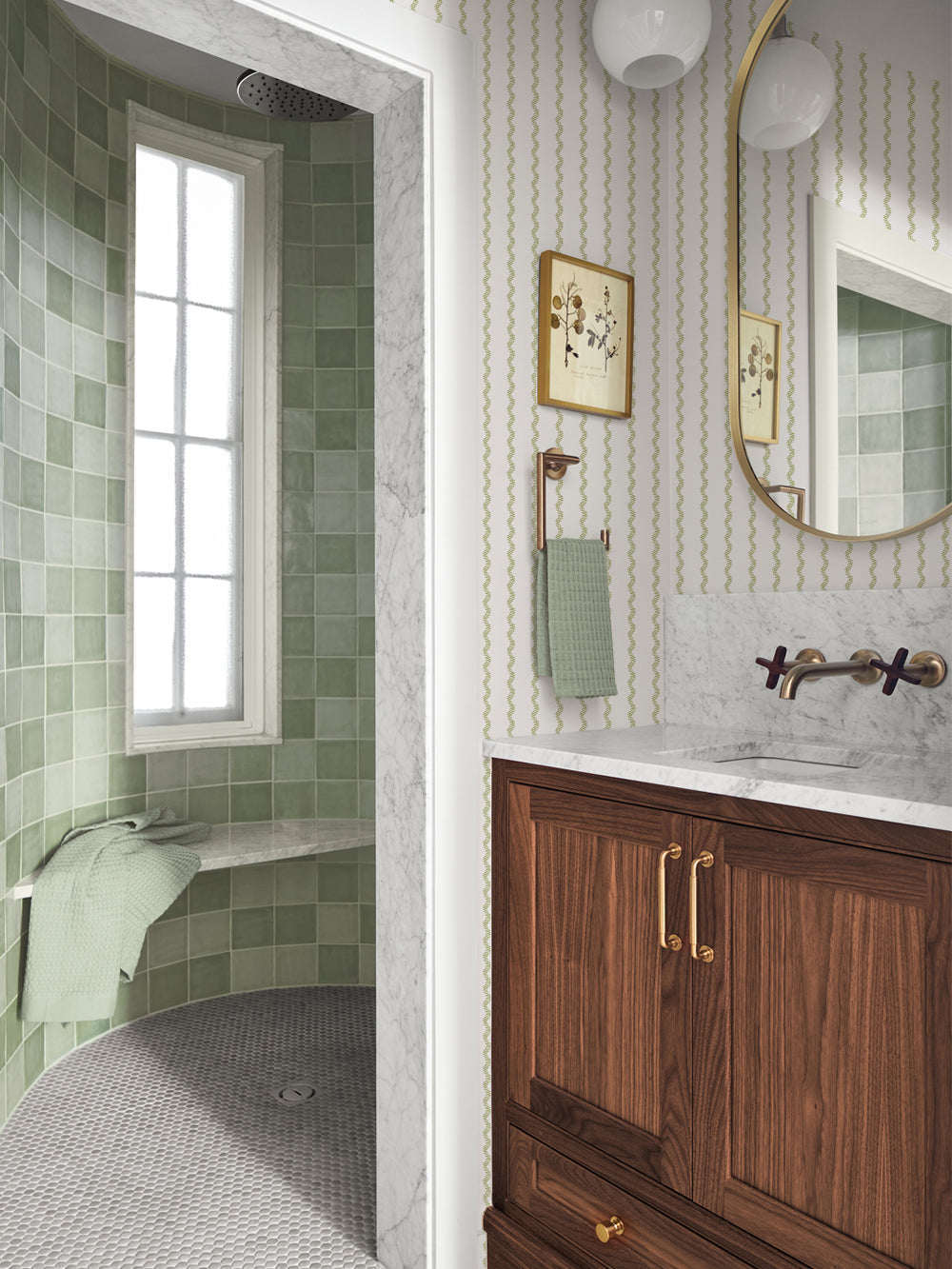 White and green stripe wallpaper in a bath with green tile shower and round brass mirror