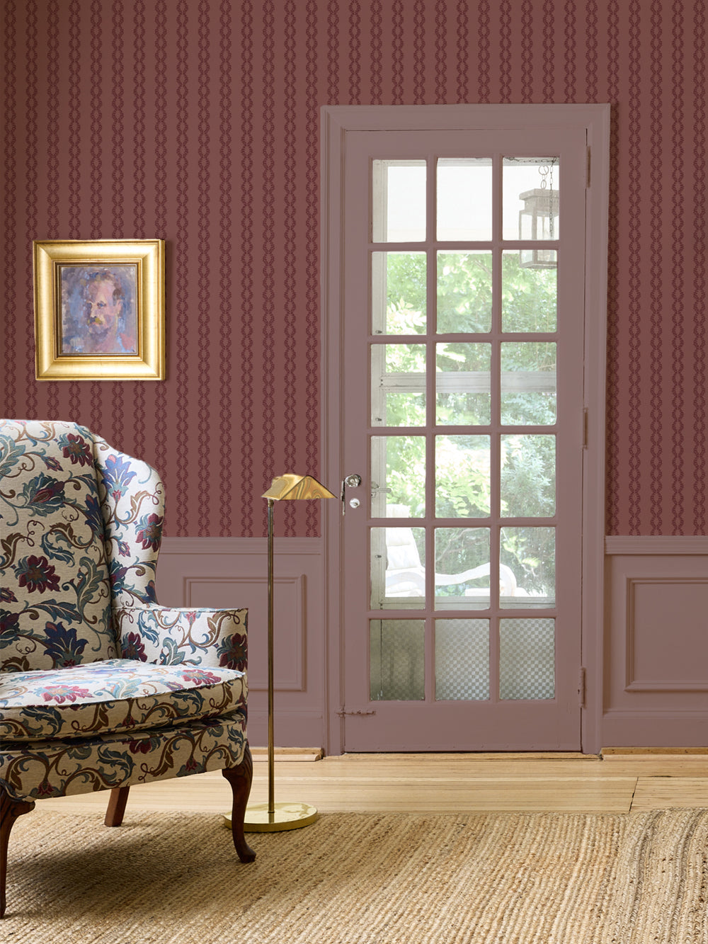 Aged Burgundy Sutton Vine wall with a floral wingback chair, brass floor lamp and mauve French door