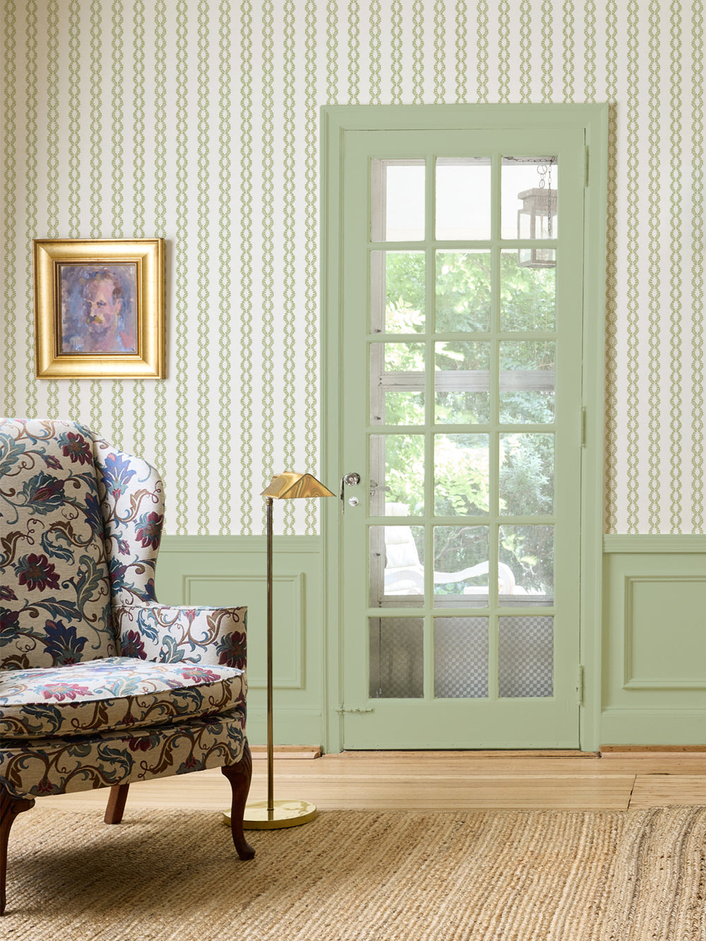 Winter Pear Sutton Vine wall with a floral wingback chair, brass floor lamp and green French door