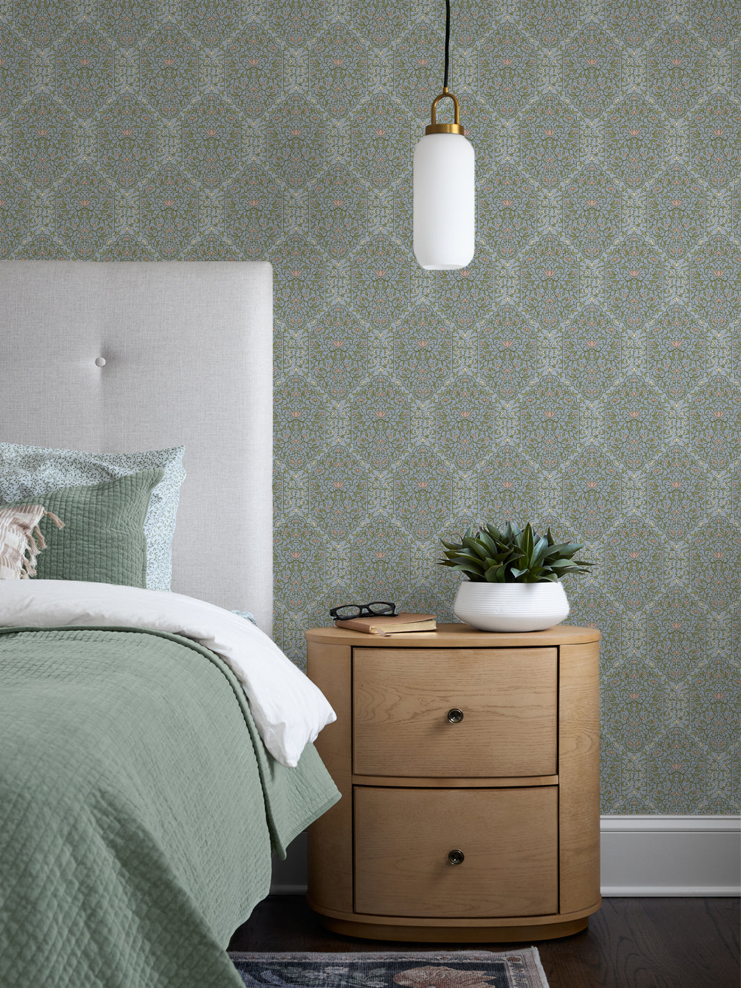 Bedroom with Dewdrop Garden Taliah Large wallpaper, grey headboard, sage quilt and oak nightstand