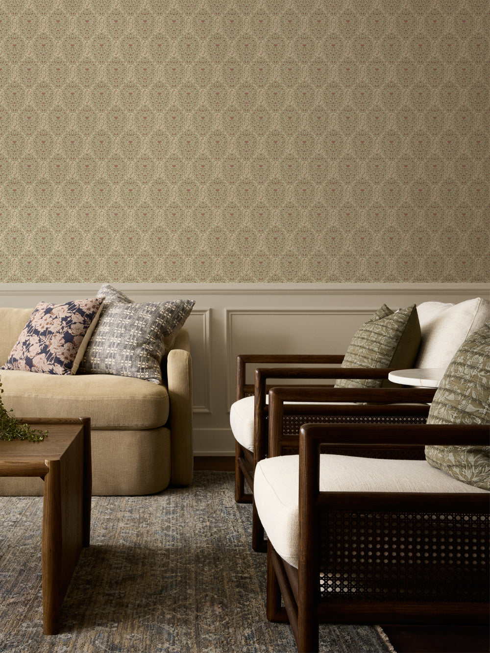 Cream and sage Taliah wallpaper above white wainscot with a beige sofa and cane armchairs