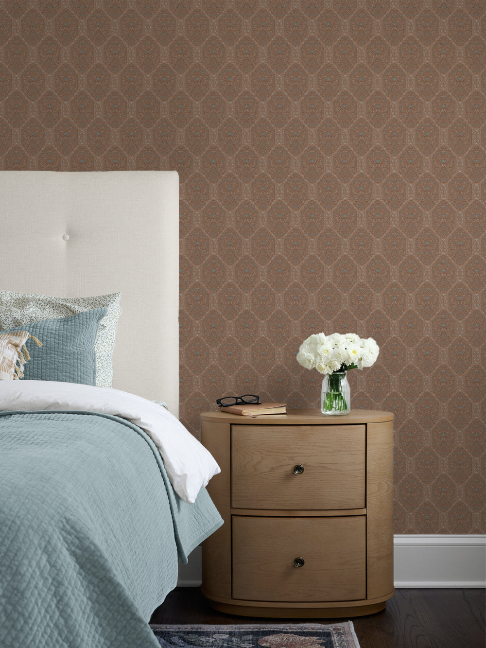 Brown Taliah wallpaper behind a cream headboard, seafoam quilt and oak nightstand