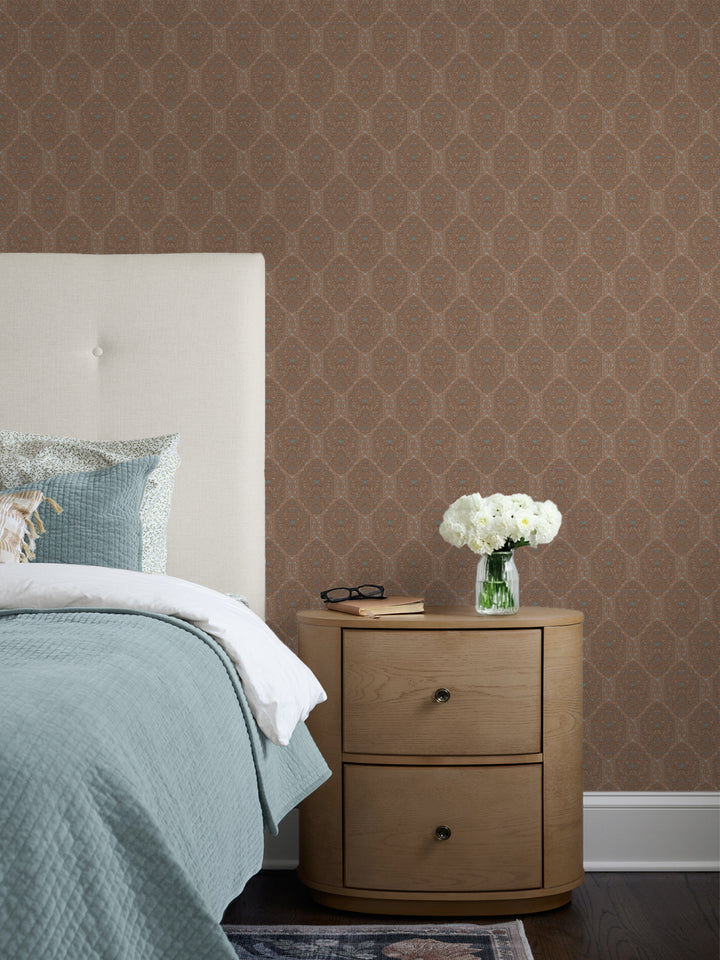 Brown Taliah wallpaper behind a cream headboard, seafoam quilt and oak nightstand