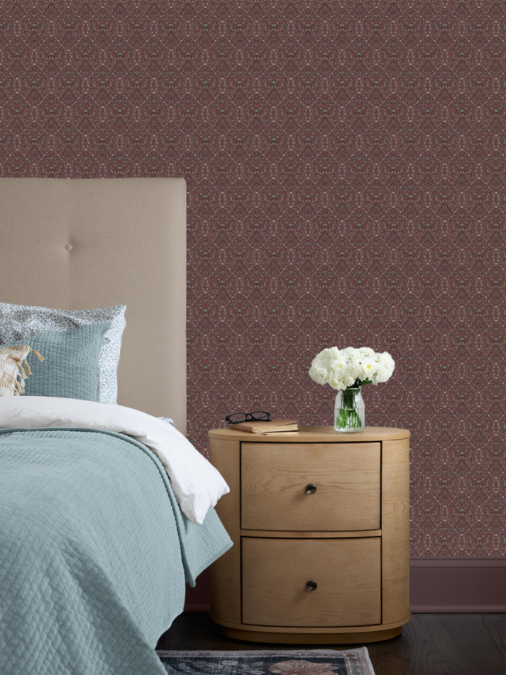 Maroon Taliah wallpaper behind a cream headboard, pale aqua quilt and oak nightstand