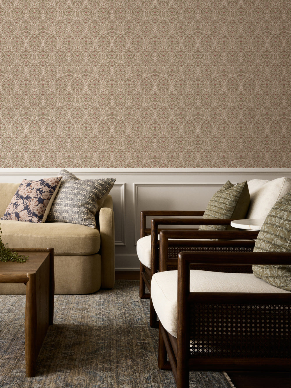 Cream and rose Taliah wallpaper above white wainscot with a beige sofa and cane armchairs