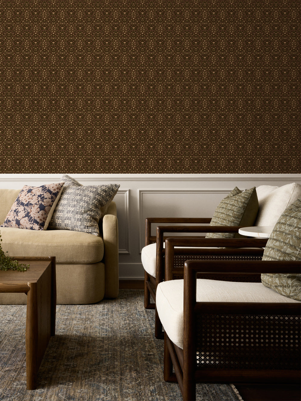 Dark brown Taliah wallpaper above white wainscot with a beige sofa and cane armchairs