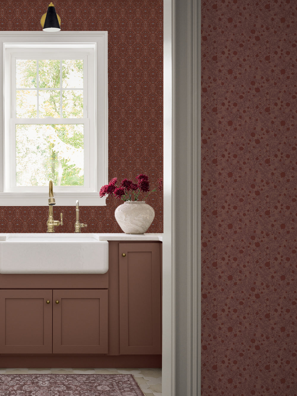 Terracotta Taliah wallpaper over a farmhouse sink with a brass faucet and clay cabinets