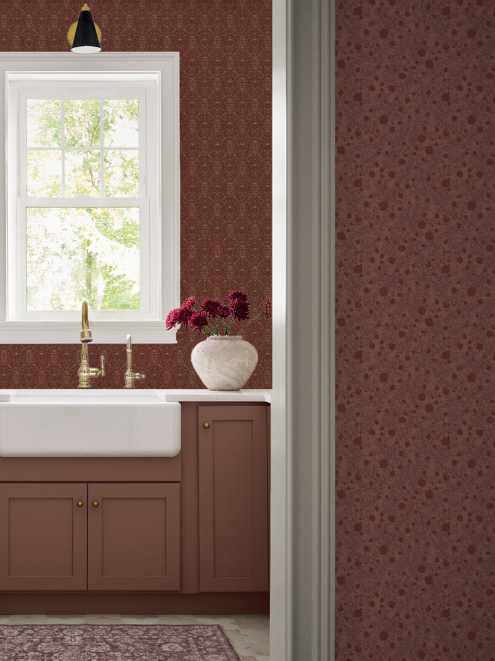 Terracotta Taliah wallpaper over a farmhouse sink with a brass faucet and clay cabinets