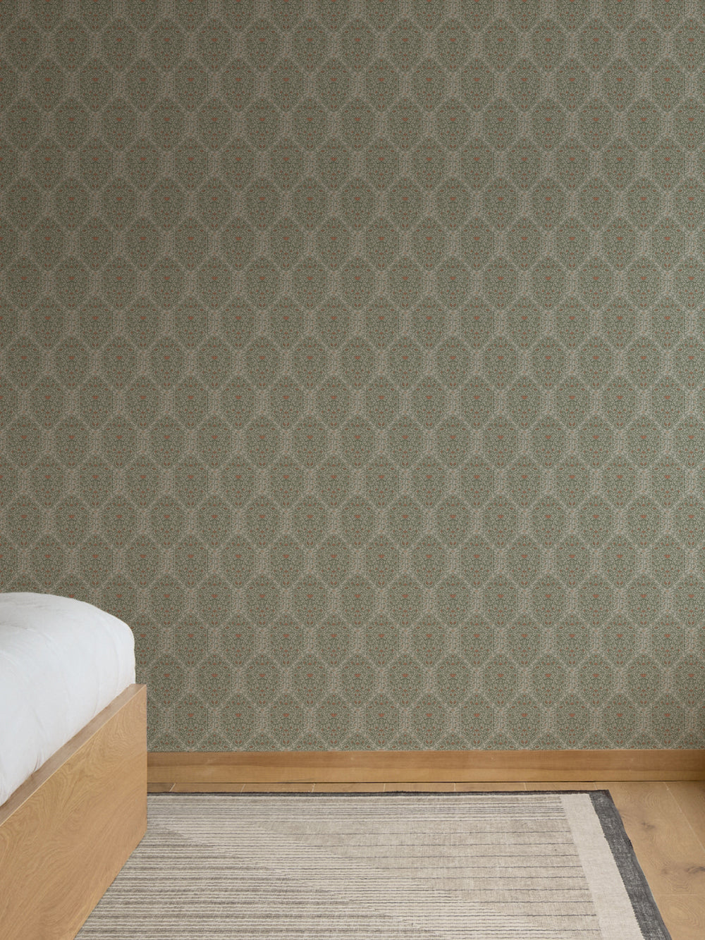 Sage green Taliah wallpaper in a bedroom with a light oak platform bed and striped rug