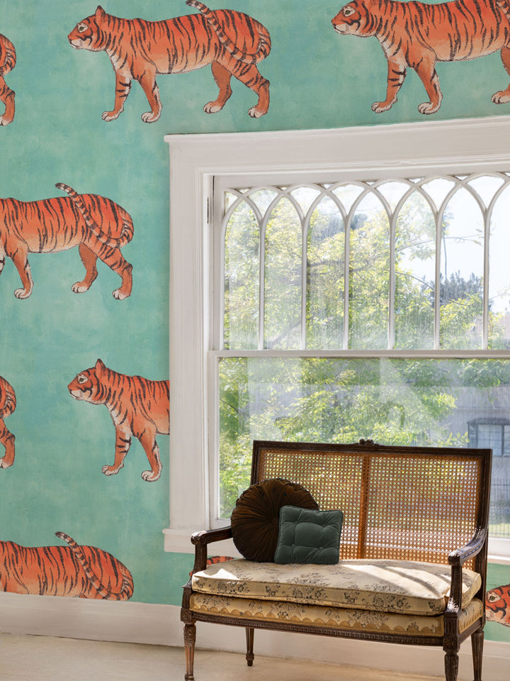 Tiger wallpaper pattern on wall with repeated orange striped tiger illustrations.