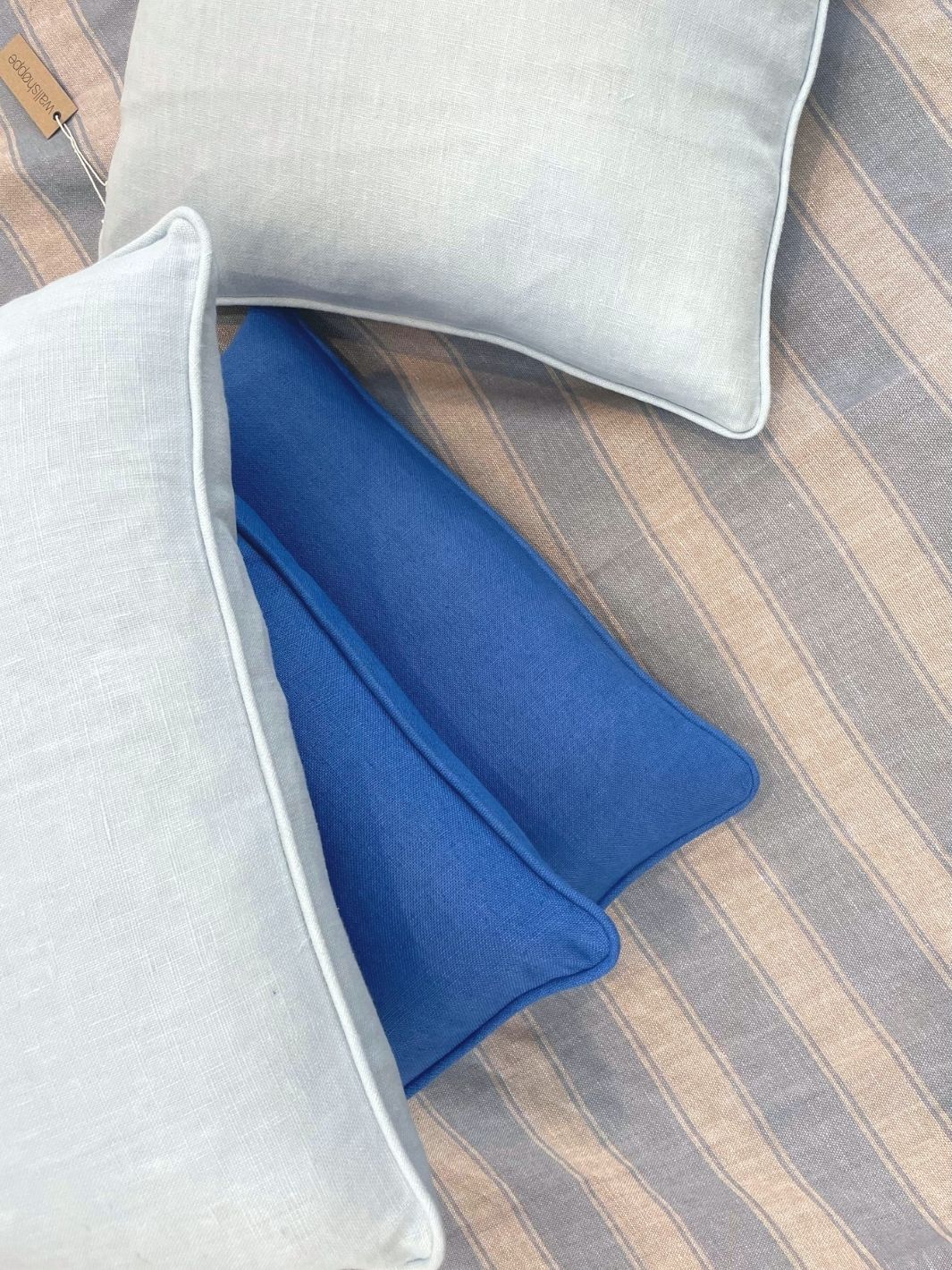 light blue solid throw pillow on linen