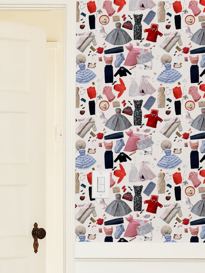 Cream wallpaper featuring scattered doll outfits, shoes, and hats in assorted colors